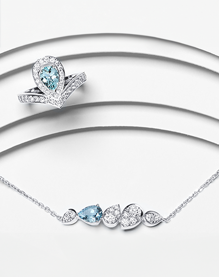 A Chaumet Jos&eacute;phine aquamarine ring and necklace on a white layered background.
